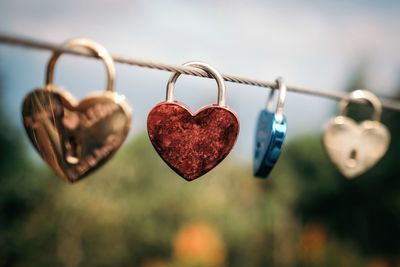Close-up of heart shape padlocks hanging on cable