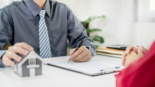 Midsection of businessman using laptop at office