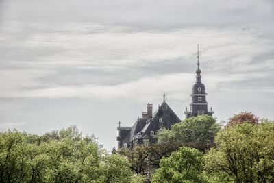 Low angle view of trees and buildings against sky