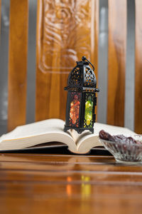 Close-up of open book on table against building