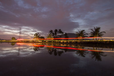 Reflection of trees in water against sky