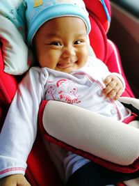 Portrait of cute smiling baby girl in stroller