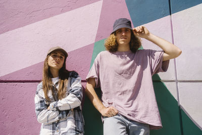 Young man with woman standing in front of colorful wall