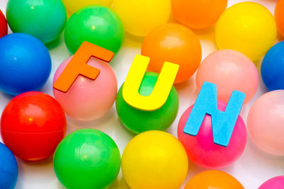 Fun text on multi colored balls over white background