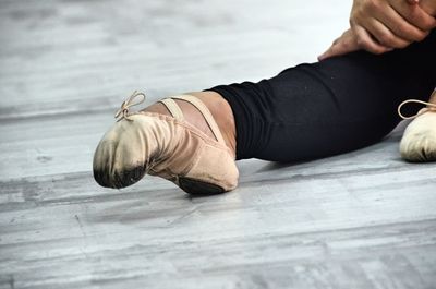 Low section of ballet dancer on floor at dance studio