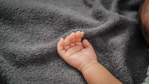 Close-up of baby hand on bed