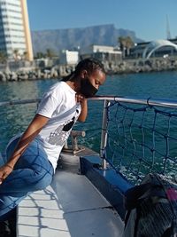 Side view of young woman in a boat looking at the sea water