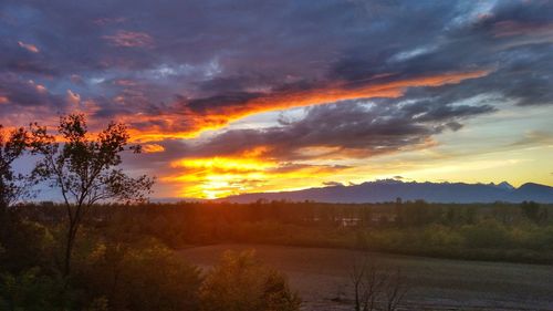 Scenic view of dramatic sky over landscape during sunset