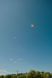 Low angle view of balloons flying against sky