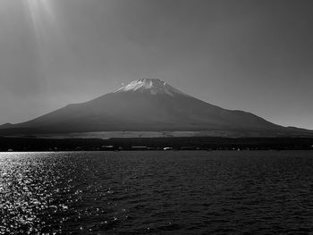 Scenic view of lake by mountains against sky