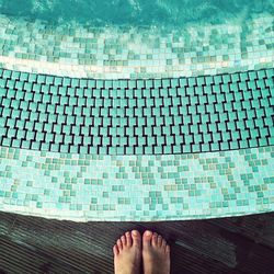 Low section of person standing on tiled floor