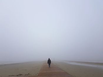 Rear view of man on land against sky