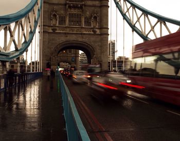 Blurred motion of cars and bus moving on tower bridge during rainy season in city