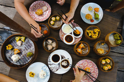 High angle view of hand holding food served on table