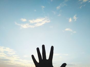 Low angle view of silhouette hand against sky