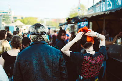 Rear view of people enjoying music concert in city