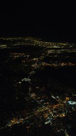 Aerial view of illuminated landscape against sky at night