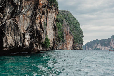 Scenic view of sea by cliff against sky