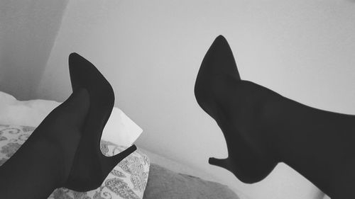 Low section of woman with shadow against white background