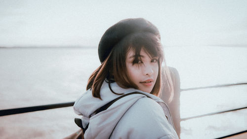 Portrait of young woman against sea