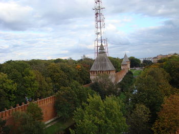 View of trees and buildings against cloudy sky