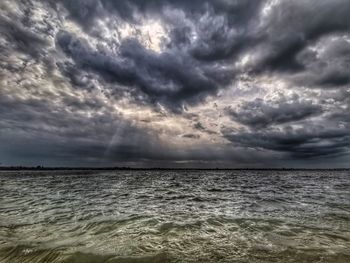 Scenic view of sea against storm clouds