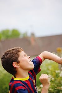 High angle view of boy playing soccer on field against sky