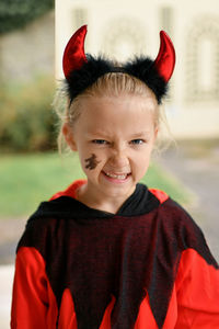 A girl dressed as a devil with horns