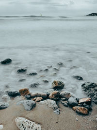 Rocks on beach against sky