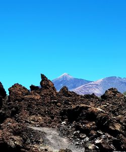 Scenic view of mountains against clear blue sky