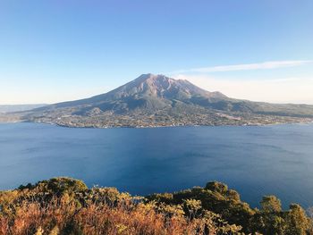 Scenic view of sea and mountains against blue sky