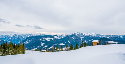 Scenic view of snowcapped mountains against cloudy sky