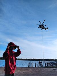 Children at lake against sky