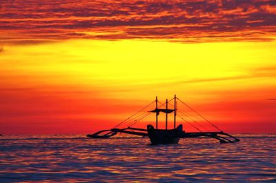 Sailboat in sea at sunset