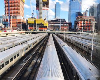 Railroad tracks amidst buildings in city against sky