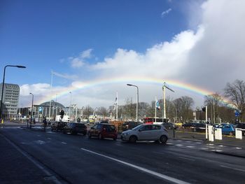 Cars on road against cloudy sky