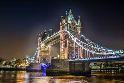 Low angle view of illuminated bridge at night