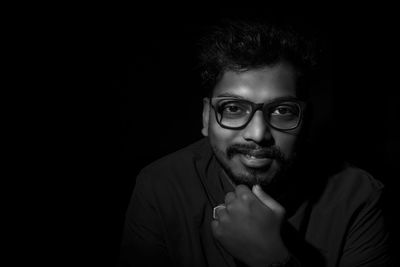 Portrait of young man against black background
