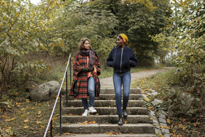 Two young women walking in park