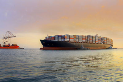 Ship in sea against sky during sunset