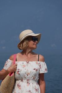 Mature woman standing by sea