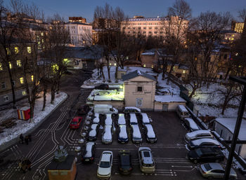 Cars on illuminated city against sky at night