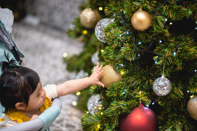 Cute baby girl touching christmas decoration