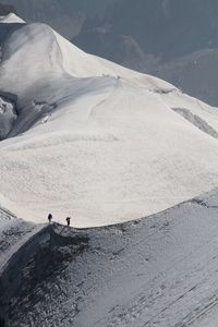 People walking on snowcapped mountain