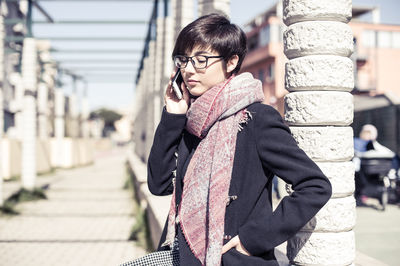 Portrait of woman using mobile phone in city