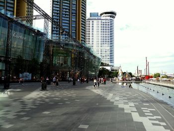 People walking on street in city against sky