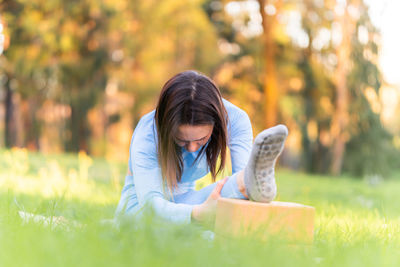 Woman sitting on grass in field