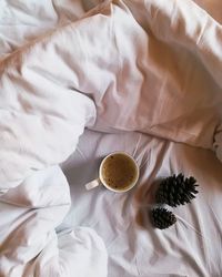 Directly above shot of coffee cup on bed