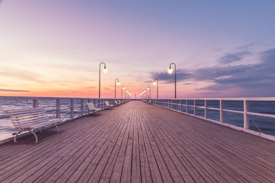 Pier over sea against sky during sunset