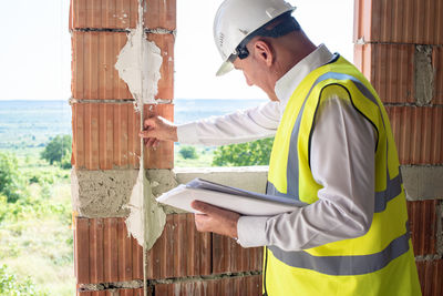 Side view of young man working at construction site